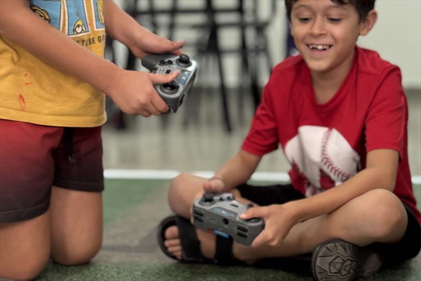 Dos chicos manejan con control remoto el robot que armaron